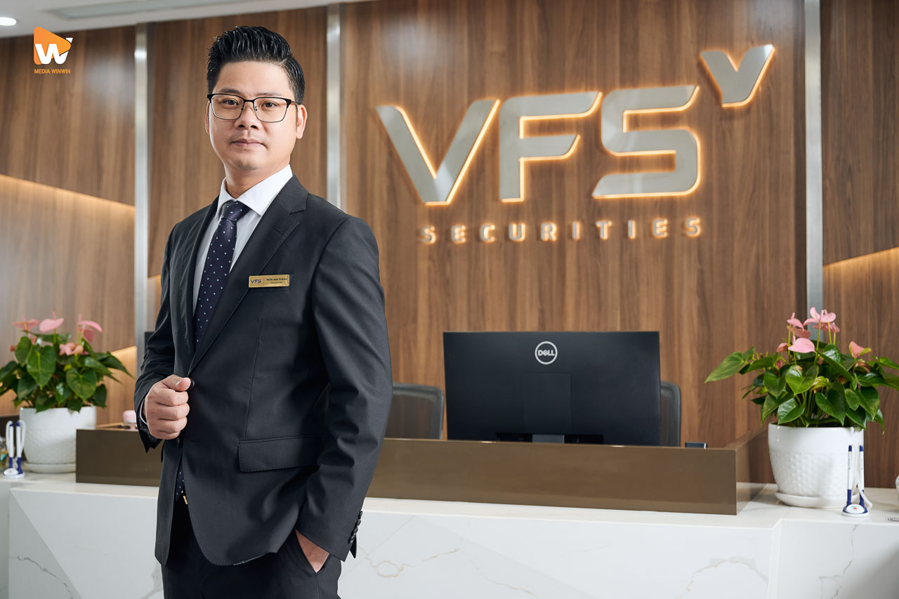 Chân dung nhân sự VFS Securities trước logo chữ nổi tại quầy giao dịch